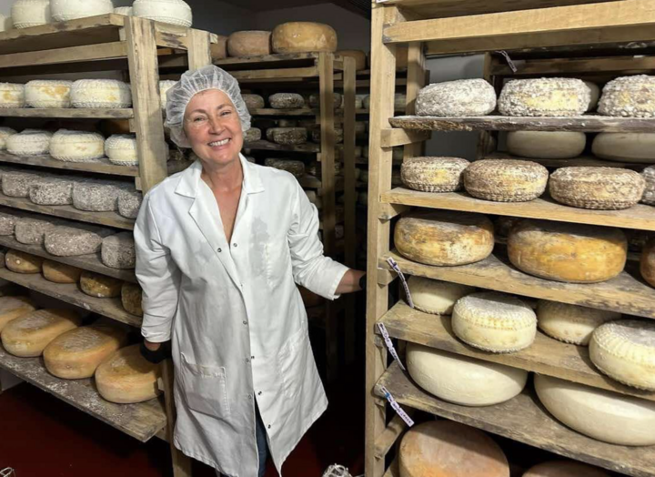 Charuth of Dutch Girl Creamery poses alongside various varieties of goat cheese